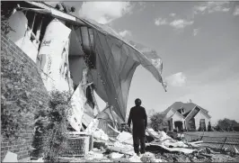  ?? ROSE BACA/THE DALLAS MORNING NEWS VIA AP ?? JOHN HAMPTON STANDS OUTSIDE HIS BROTHER’S HOUSE that was damaged following a storm early in the morning in Rockwall, Texas, on Wednesday. A powerful storm system with winds exceeding 60 mph has damaged homes in suburban Dallas, knocked out power to...