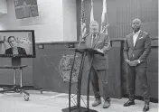  ?? RYAN GILLESPIE Orlando Sentinel/TNS ?? Larry Schooler, appearing virtually on the left, addresses reporters alongside Orlando Mayor Buddy Dyer and City Commission­er Bakari Burns. Schooler was contracted to do outreach to Pulse survivors and families of victims as the city tries to build a memorial.