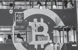  ?? KIN CHEUNG/AP ?? Bitcoin and Ethereum, the top two cryptocurr­encies also known for volatility, recently reached record-high values. Above, an ad for Bitcoin on a tram in Hong Kong.