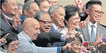  ?? AP ?? Former Hong Kong Chief Secretary Carrie Lam, second from right, poses with her supporters after declaring her victory in the chief executive election yesterday.
