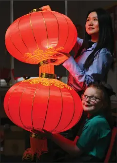  ??  ?? Sophie with teacher Yuanyuan Cui holding up two Chinese lanterns
