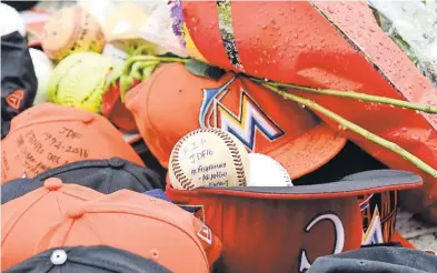  ?? STEVE MITCHELL, USA TODAY SPORTS ?? Fans have left caps, baseballs and other items with messages in amemorial for Jose Fernandez outside Marlins Park.