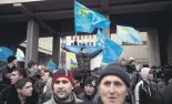  ??  ?? Crimean Tatars hold flags during rallies near the Crimean parliament building against Russian occupation in Simferopol, on Feb. 26, 2014.