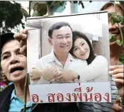  ?? AFP PHOTO ?? MASIH DICINTA: Pendukung keluarga Shinawatra membawa foto Thaksin dan Yingluck saat berdemo awal bulan lalu.