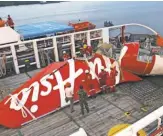  ?? ACHMAD IBRAHIM, AP ?? Workers unload the tail section of AirAsia Flight 8501 in Indonesia, on Jan. 11.