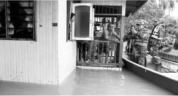  ??  ?? Nazili (third right) giving advice to Nasir during his flood check at the village in the flood-hit areas. — Bernama photo