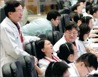  ?? JIN LIWANG / XINHUA ?? Scientists who helped guide the Chang’e 4 probe’s soft landing on the moon’s far side celebrate the historic event at the Beijing Aerospace Control Center on Thursday.