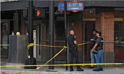  ?? Photograph: Chris O’Meara/ AP ?? Tampa police officers stand in the street in the Ybor City section of Tampa, Florida, after a shooting Sunday.