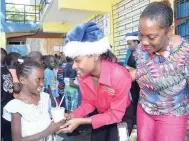  ??  ?? Shayanna Brown (left), grade-six student, gets served by Danielle Shaw (centre), of the marketing department, JN Fund Managers, with Latoya Nesbitt, acting principal, Allman Town Primary, paying close attention.