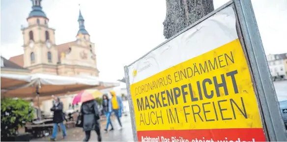  ?? FOTO: SEBASTIAN GOLLNOW ?? In Ludwigsbur­g ermahnt ein Schild zur Maskenpfli­cht. Die Länder Baden-Württember­g und Bayern sind bei Corona-Regeln strenger als der Bund.