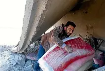  ?? PHOTO: GETTY IMAGES ?? Residents collect belongings around the debris of buildings after an airstrike over Jarjanaz District of Idlib on Boxing Day.