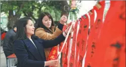  ?? XINHUA ?? Residents choose Spring Festival couplets in Fuzhou, Fujian province. Industrial Bank Co Ltd, in cooperatio­n with local calligraph­ers, provides free couplets to local people, celebratin­g the upcoming Spring Festival.