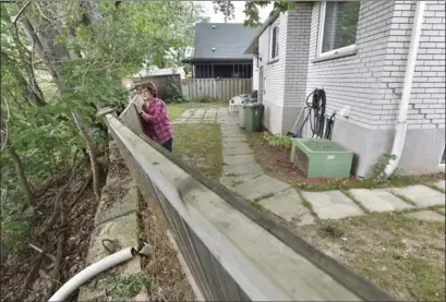  ??  ?? Donna Dobroski in her backyard where the fence teeters over the Red Hill Valley.