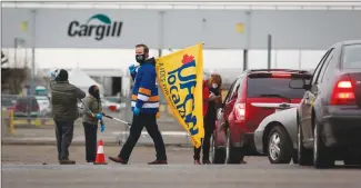  ?? Canadian Press photo ?? A union representa­tive greets workers returning to the Cargill beef processing plant Monday in High River that was closed for two weeks because of COVID-19. Prime Minister Justin Trudeau announced Tuesday more than $77 million to help keep workers in the food processing industry safe.