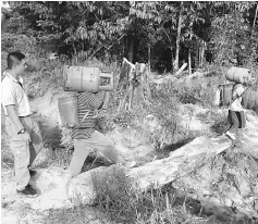  ??  ?? Two villagers carrying cooking gas cylinders to their village, a journey of about 30 minutes by foot.