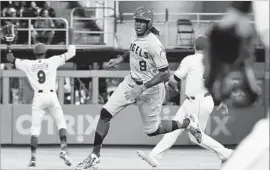  ?? Eric Espada Getty Images ?? CAMERON MAYBIN of the Angels heads for third base with a triple in the third inning against Vance Worley of the Miami Marlins. Maybin also had a single.