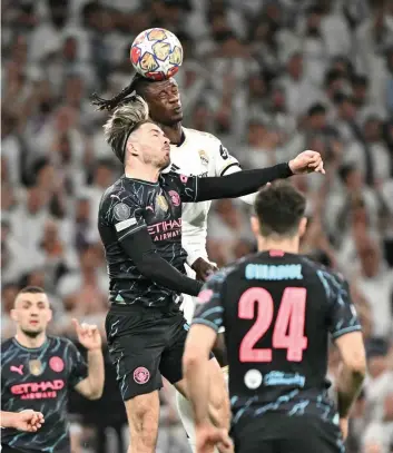  ?? — AFP ?? Real Madrid’s French midfielder Eduardo Camavinga (R) vies for a header with Manchester City’s English midfielder Jack Grealish during the Uefa Champions League quarterfin­al first leg match between Real Madrid CF and Manchester City at the Santiago Bernabeu Stadium in Madrid.