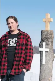  ?? JUSTIN TANG / THE CANADIAN PRESS ?? Blake Murray, who was dispatched to take down some dead trees in Ottawa, carved a cross in one of them with his chainsaw when he saw it was a memorial.