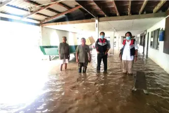  ?? ?? Dennis (second right) and Baram MP Anyi Ngau (right) checking on the flood situation in Long Bemang