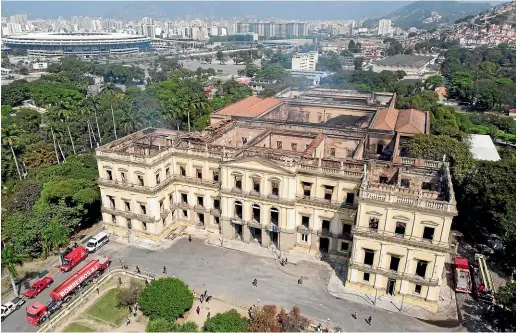  ?? AP ?? Firetrucks sit parked outside the National Museum after it was gutted by an overnight fire in Rio de Janeiro, Brazil.