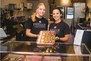  ?? STEVE SMITH/COURANT COMMUNITY ?? Employee Tess Lewis-holcombe, left, and owner Nicole Palazzo show off some of the mini-doughnut varieties available at Indulge by Palazzo in Wethersfie­ld.