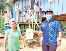  ??  ?? A teacher from SK Sangau handing over a set of modules to one of their parents in Kg Kulu-Kulu. - Photo courtesy of Guru SK Sangau