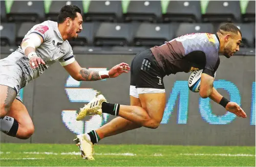  ?? PICTURES: Getty Images ?? Gas to burn: Quins centre Joe Marchant scores his first try past Denny Solomona