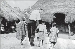  ?? Don Royle Associated Press ?? A PILLAR IN THE CHRISTIAN WORLD During a 1960 crusade in Africa, Graham holds hands with children in a Nigerian village. He reportedly preached to nearly 215 million people in more than 185 countries and territorie­s.