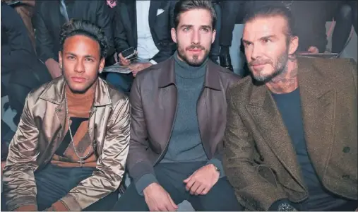  ??  ?? FASTIDIO. Neymar asiste a un desfile de la Semana de la Moda de París al lado de su compañero Trapp y de David Beckham.