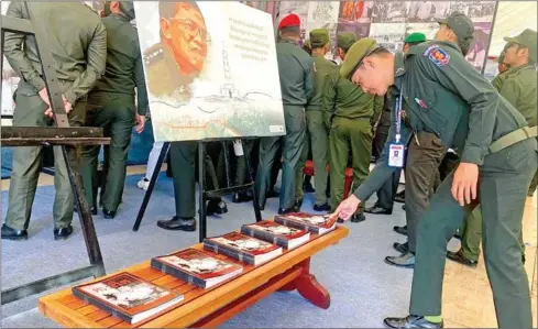  ?? DC-CAM ?? A soldier picks up a Truth Magazine under a portrait of Prime Minister Hun Sen, ahead of Win-Win Policy Day, on December 28.
