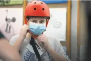  ??  ?? Solly Bobrowsky, 13, tries on a new helmet to go with his bike bought at the longtime rental store.