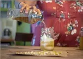  ?? Alexandra Wimley/Post-Gazette ?? Sherrie Flick prepares a chamomile cocktail made from wild plants in her garden on the South Side Slopes.