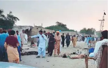  ?? AFP ?? Worshipper­s gather around the bodies of blast victims after a suicide bomber blew himself up near a Sufi shrine in the Gandawa area of Jhal Magsi district yesterday.