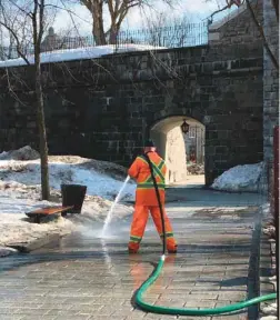  ?? MARIE-MICHELLE SIOUI LE DEVOIR ?? Des employés municipaux arrosaient lundi les trottoirs du Vieux-Québec à grande eau pour les nettoyer. Leur tuyau était connecté à une borne-fontaine.
