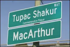  ?? ASSOCIATED PRESS ?? A new sign is unveiled Friday following a street renaming ceremony for Tupac Shakur in Oakland. A stretch of street in Oakland was renamed for Shakur, 27 years after the killing of the hip-hop luminary.