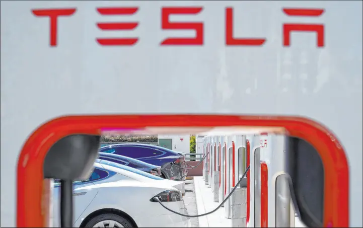  ?? Godofredo A. Vásquez The Associated Press ?? Tesla vehicles charge last year at a station in Emeryville, Calif. The White House announced a plan in which Tesla will make some of its charging stations available to all EVS.