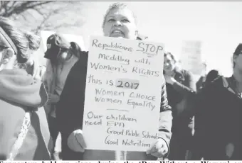  ?? REUTERS/Joshua Roberts ?? Supporters hold up signs during the ‘Day Without a Woman’ on Internatio­nal Women’s Day at the U.S. Capitol in Washington, U.S., March 8, 2017.