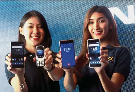  ??  ?? Models posing with the Nokia 5 (left), 3310 (second from left), and Nokia 6. — IBRAHIM MOHTAR/The Star