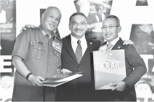  ?? — Gambar Bernama ?? MESRA: Hishammudd­in (tengah) bergambar bersama Panglima Angkatan Tentera Jeneral Tan Sri Raja Mohamed Affandi Raja Mohamed Noor (kiri) dan Abdul Rahim pada majlis Ikrar Kementeria­n Pertahanan: Perteguh Negaraku di Dewan Perkasa, Wisma Perwira, Angkatan...