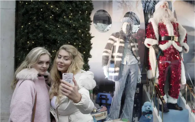  ??  ?? LONDON: Two shoppers stop to take a selfie in front of Selfridges window display on Oxford Street, one of the main shopping streets in central London yesterday. Confoundin­g economists, Britain’s economy has grown solidly since the June referendum,...