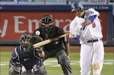  ?? MARK J. TERRILL — THE ASSOCIATED PRESS ?? The Dodgers’ Manny Machado hits a solo home run as Brewers catcher Manny Pina watches along with home plate umpire Pat Hoberg during the ninth inning July 30. Milwaukee won, 5-2.