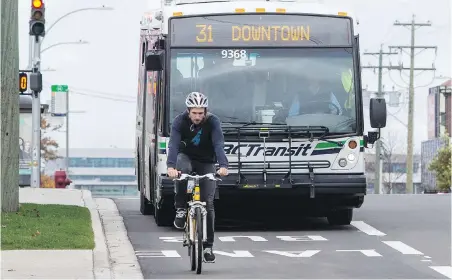  ??  ?? A cyclist travels ahead of a transit bus in the southbound bus lane on Douglas Street, near Burnside Road East.