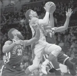  ?? Mary Altaffer Associated Press ?? JOSH HART, who had 15 points and a career-high 14 rebounds in a starting role, drives past Brooklyn’s Allen Crabbe, left, and Spencer Dinwiddie.