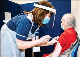  ??  ?? SHOT IN THE ARM: Margery Fairley receives her jab from nurse Jackie Dobson, who is also pictured above ready for action with four of her colleagues