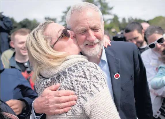  ??  ?? > Labour leader Jeremy Corbyn is kissed by a supporter at a rally in Harlow, Essex, yesterday