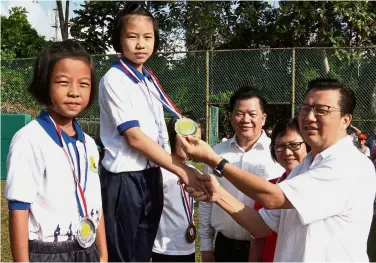  ??  ?? Good sport: Liow presenting medals to students during sports day at SJK (C) Karak. Looking on are the school board chairman Datuk Yeong Onn San and headmistre­ss Wong Lee Chan.