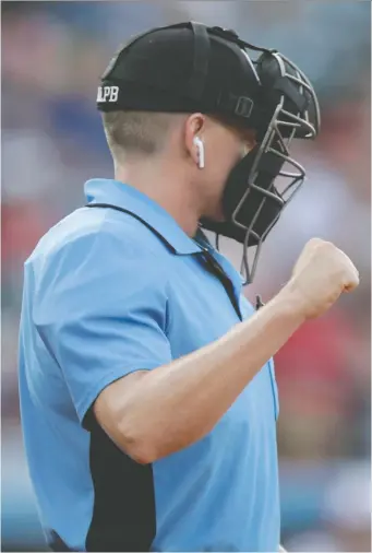  ?? JULIO CORTEZ/THE ASSOCIATED PRESS ?? Atlantic League umpire Brian deBrauwere signals a strike after the call was relayed to him through an earpiece from a computer system that employs radar to track pitches. At least one minor league affiliated with MLB will use a similar system next season, commission­er Rob Manfred says.