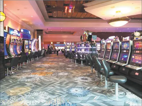  ?? Liz Teitz / ?? A sparse Foxwoods Resort Casino slot machine floor in March 2020, in advance of the casinos closing in response to the COVID-19 pandemic. In the weeks to follow, eastern Connecticu­t towns bore the biggest brunt of job losses as reported to the state by those thrown out of work who are seeking unemployme­nt compensati­on.