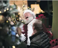  ??  ?? Santa Claus (Doug Bell, 58) has a hearty belly laugh at Southcentr­e Mall during pictures with Santa. Bell has been spreading Christmas cheer throughout Calgary as the jolly old elf for more than 20 years.