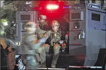  ?? JAE C. HONG / ASSOCIATED PRESS ?? ATF agents board a truck to conduct a raid early Wednesday morning in Los Angeles. Federal and local agencies used tactical and SWAT teams to serve some of the warrants, and 21 people were arrested in predawn raids.
